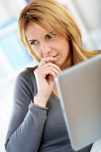 女人在数字平板电脑的首页 websurfing