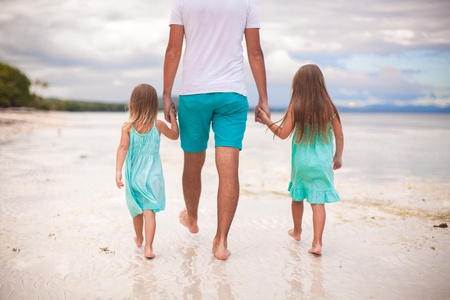 后视图的父亲和他的两个孩子在海边散步
