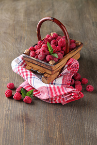 成熟甜树莓在木制背景上篮