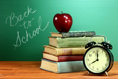 学校图书 苹果和在学校的办公桌上的时钟
