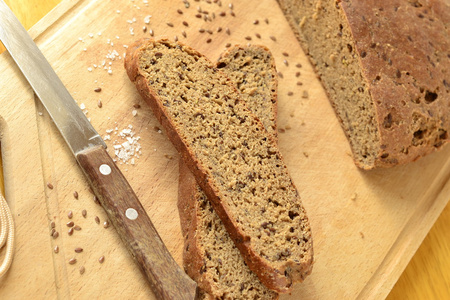 自制橄榄黑麦面包与亚麻籽在木板上