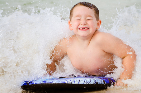 儿童在 bodyboard 在海滩上冲浪