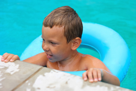 在寒暑假期间在游泳池中游泳的学龄前的孩子