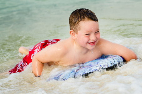 儿童在 bodyboard 在海滩上冲浪