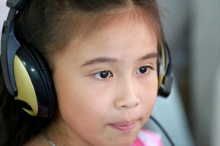 笔记本电脑使用耳机的小女孩