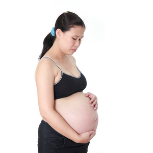 怀孕的女人爱抚着她的肚子里在白色背景上