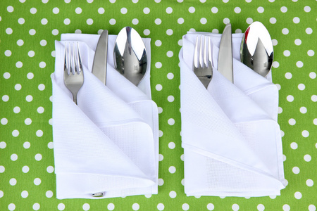 折的餐巾与叉子 勺子和颜色背景上刀