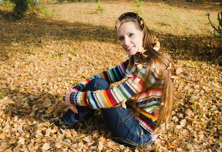 美丽的年轻女子走在秋天的木头上
