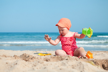 坐在沙子在海滩上的小女孩