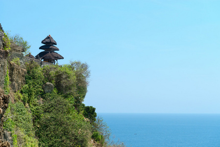 巴厘岛寺庙在岩石上面蓝色热带海