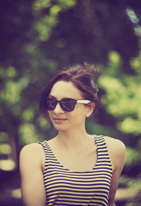 一个年轻的女人戴着墨镜与美容散景的程式化的 instagram 彩色复古时尚肖像