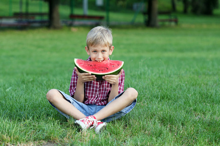 男孩在公园吃西瓜
