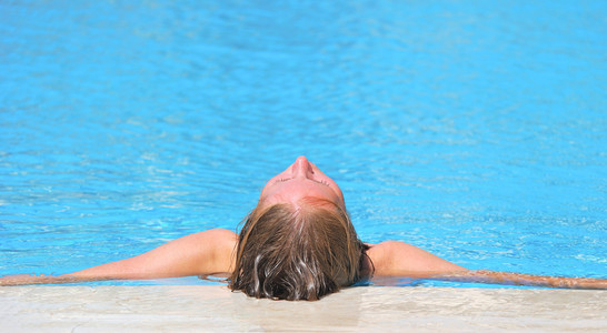 女人放松在蓝色室外游泳 waterpool