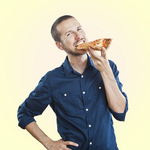 年轻美丽的男人吃一片比萨饼玛格丽塔的肖像