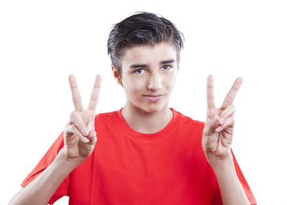 英俊的年轻男孩，在白色背景上显示胜利的手势的肖像
