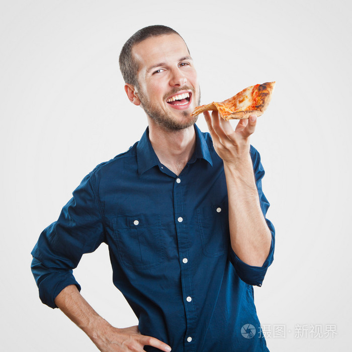 年轻美丽的男人吃一片比萨饼玛格丽塔的肖像