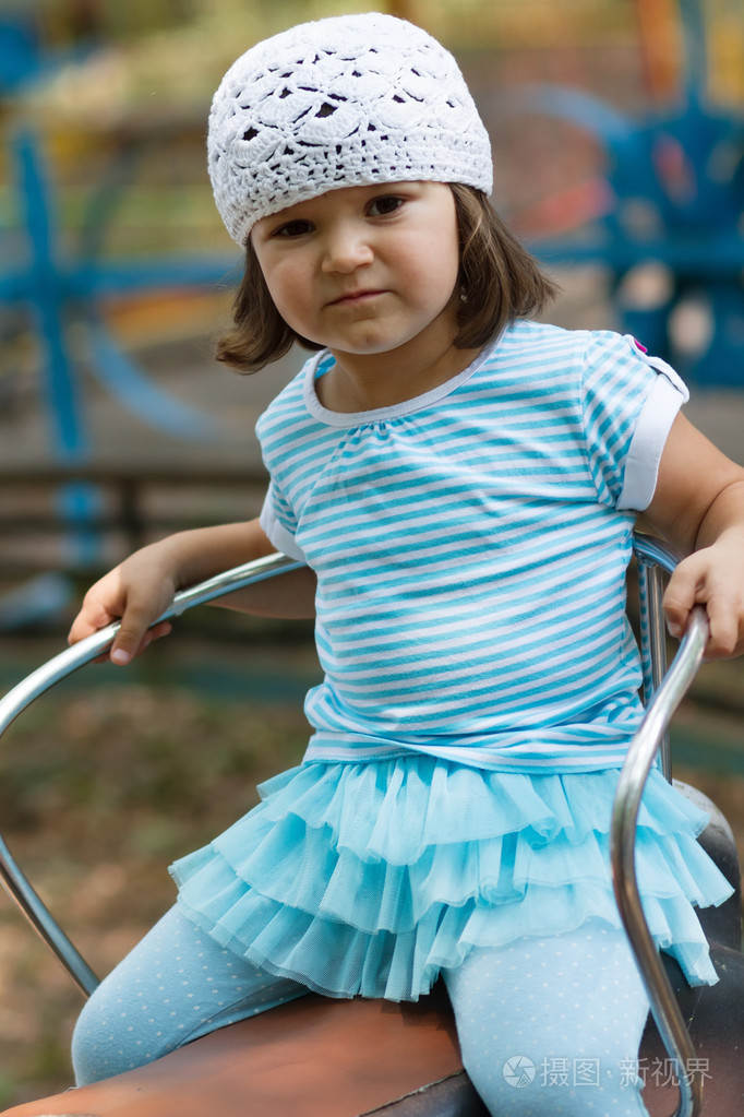 小女孩骑着木马在amuzement公园