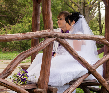 在爱新娘和新郎姿势坐在木板凳上几