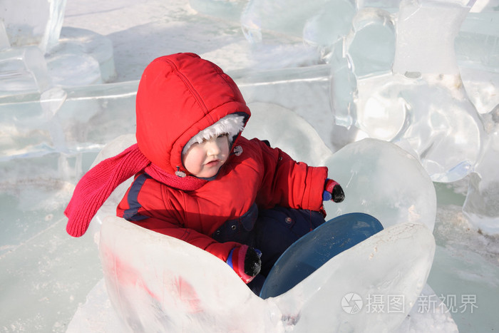 在冬天穿保暖连身衣小女孩坐在冰 nenuphar