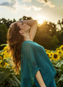 年轻漂亮的女人上盛开向日葵场的夏天