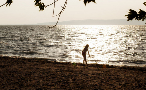 在日落海滩上玩的孩子剪影
