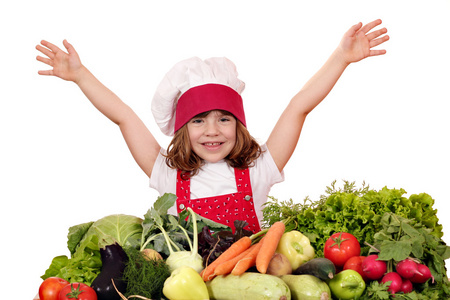 快乐的小女孩用蔬菜煮熟
