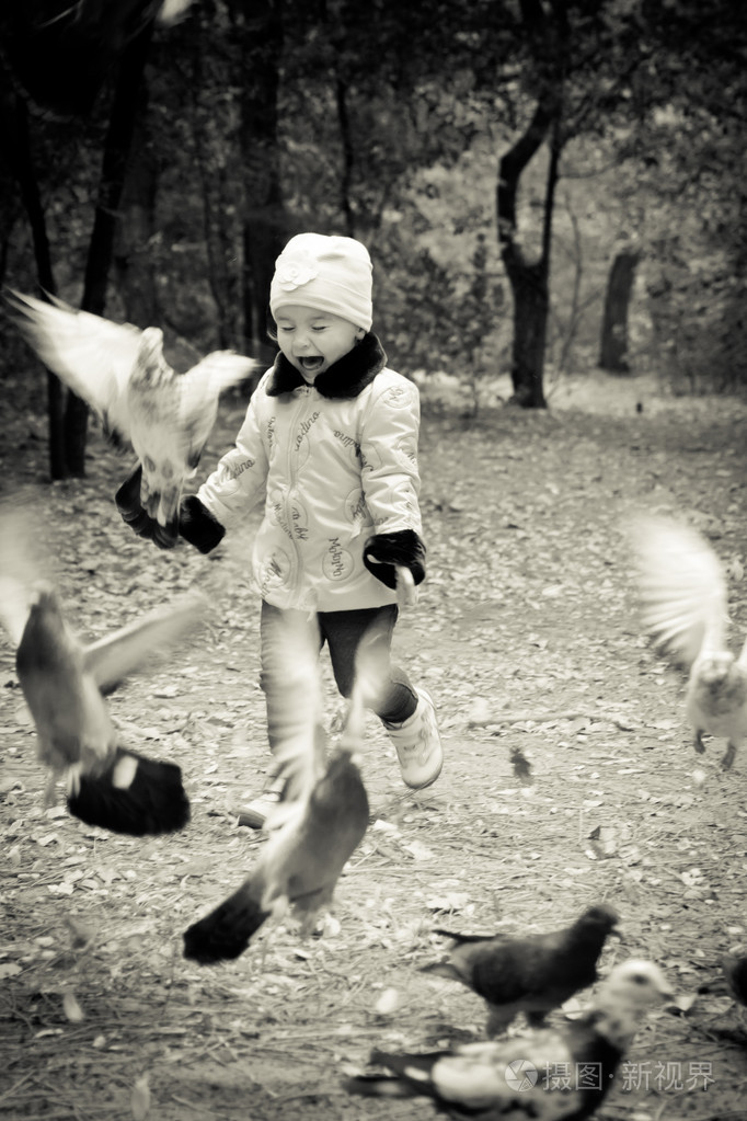 小可爱女孩与鸽子在秋园