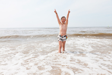 在大海的波浪中海滩很开心的孩子男孩