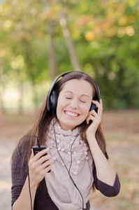 漂亮年轻微笑的女人听音乐