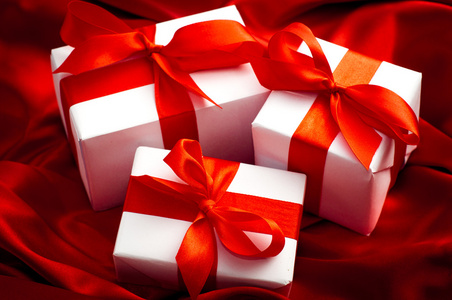 情人节礼品盒带有红色缎面背景上红色缎带蝴蝶结绑