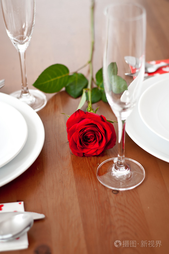带有玫瑰和香槟酒杯的浪漫晚餐环境