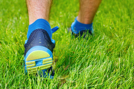 一名男子跑步者站在草地上的特写镜头