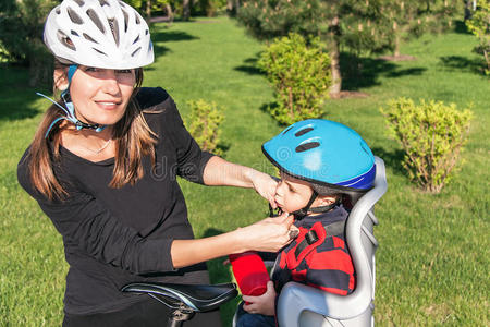 骑着自行车戴着自行车头盔的白人妇女和男婴。