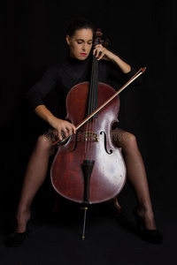 一个漂亮的女人拉着有选择性的光和黑d大提琴