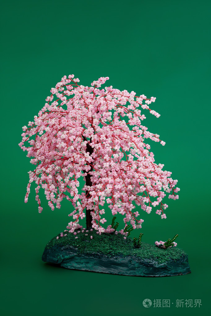 从绿色背景上的玻璃珠工艺品树