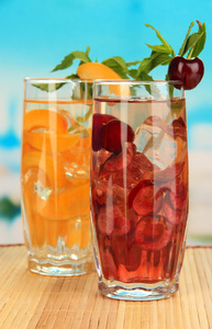 水果饮料与冰蓝色背景上的多维数据集的眼镜