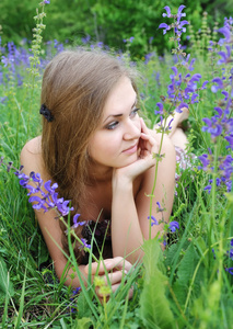 美丽的年轻女子在户外的紫罗兰花