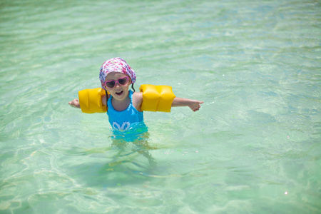 小可爱快乐女孩泳装在海中有好玩