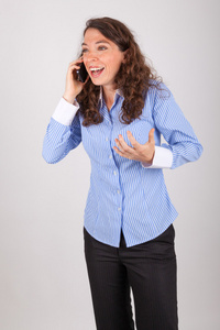 年轻商业女人是在电话上与她的手机