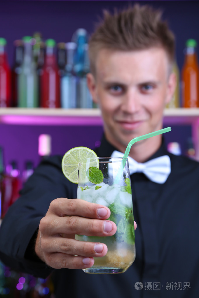 肖像的英俊男服务员与莫西多鸡尾酒鸡尾酒，在酒吧