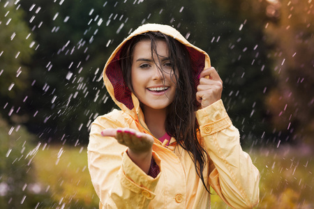 穿着黄色雨衣的年轻漂亮女人