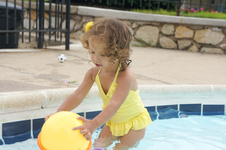 可爱的小女孩在池中找乐子