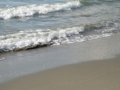 泡沫水洗在沙滩上的海岸图片
