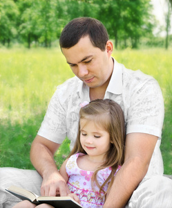 在公园里读书的女儿与父亲