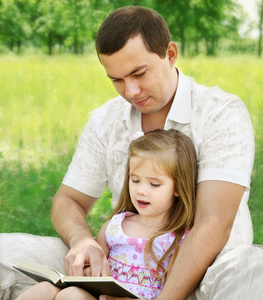 在公园里读书的女儿与父亲