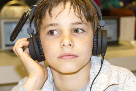 一个甜美的小男孩，听音乐头戴式耳机的肖像