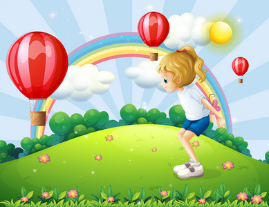 在小山与漂浮的气球玩一个女孩