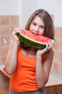 美丽少女与切片的新鲜西瓜.young 女孩吃的十几岁的女孩红色 t 恤和长长的头发在鸡举行西瓜切片 watermelon.por