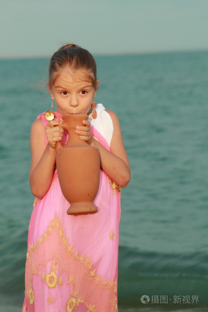 在漂亮的衣服在希腊风格与安芙兰微笑着可爱的小女孩