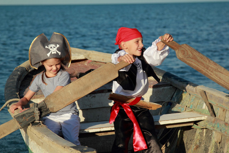 白种人快乐小儿童在海面上打海盗